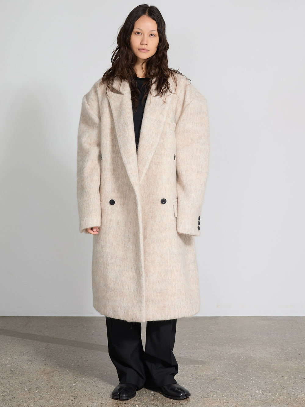 A model showcases a cozy, oversized beige coat with a double-breasted design, embodying MEOTINE's chic style.